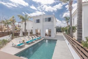 Casa blanca con piscina y palmeras en EvelMar Villa, en Protaras