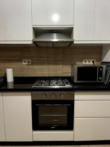 eine Küche mit Herd und Mikrowelle in der Unterkunft Appartement au coeur d'Agadir in Agadir