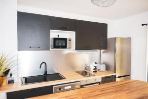 a kitchen with a sink and a microwave at La parenthèse in Courcelles Sucrerie +9 photos