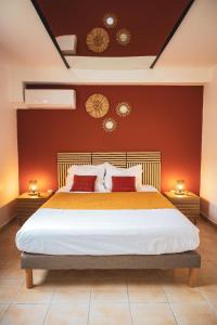 a bedroom with a large bed with red walls at La parenthèse in Courcelles Sucrerie