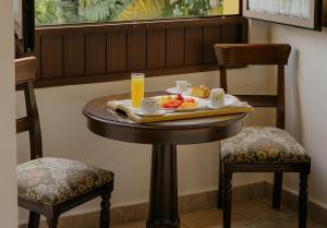 a table with a tray of food and two chairs at Hotel Hacienda Los Laureles in Oaxaca City +33 photos