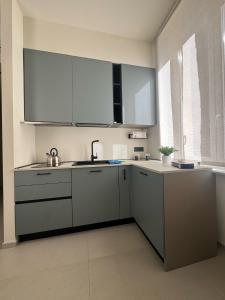 Una cocina con gabinetes blancos y un fregadero. en Holiday Home 63, en Nápoles