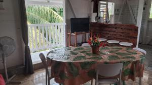 a table with chairs and a table with a table cloth at Le Bon Logis du Carbet in Capesterre-Belle-Eau