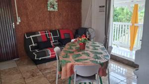 a dining room with a table with flowers on it at Le Bon Logis du Carbet in Capesterre-Belle-Eau