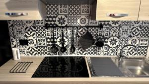 a kitchen with black and white tiles on the wall at A casa di Agata in Capua +10 photos