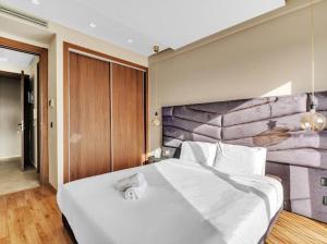 カサブランカにあるLuxury app in Val Fleuriの石壁のベッドルーム1室(白い大型ベッド1台付)