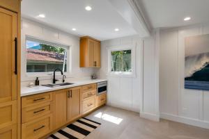 a kitchen with wooden cabinets and a sink and two windows at Camp Magic 2 in Hanalei +60 photos