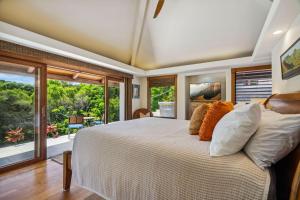 a bedroom with a large bed and a large window at Kapiolani - As seen on HGTV in Princeville