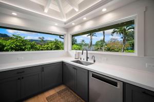 a kitchen with a sink and two large windows at Camp Magic 1 in Hanalei +45 photos
