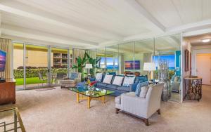 a large living room with a blue couch and chairs at Whaler 102 in Lahaina