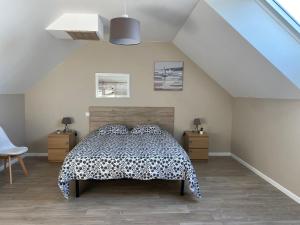 1 dormitorio con 1 cama con colcha en blanco y negro en La cabane du banc José, en Le Rozel