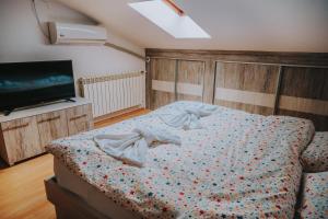 a bedroom with a bed and a flat screen tv at Bisera Apartments in Ohrid