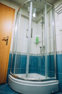 a shower in a bathroom with blue and white tiles at Bisera Apartments in Ohrid +22 photos