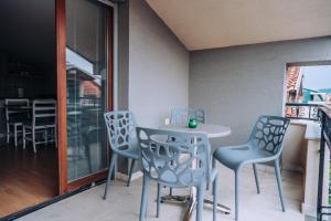 a dining room with chairs and a table and a window at Bisera Apartments in Ohrid
