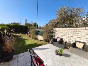 a patio with a table and chairs in a backyard at Maison 4 chambres proche Reims in Tinqueux