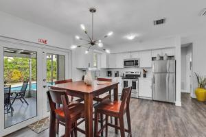 Una cocina con mesa y sillas y un refrigerador. en 3Bed Modern Home Family Friendly Heated Pool, en Fort Lauderdale