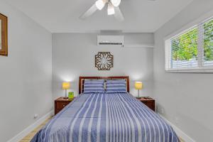 1 dormitorio con 1 cama con edredón de rayas azules en 3Bed Modern Home Family Friendly Heated Pool, en Fort Lauderdale 24 fotos más