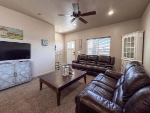 a living room with leather furniture and a flat screen tv at Bear Lake Escape-Pet Friendly in Garden City