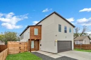 a white house with a wooden fence at Modern 4 Bedroom Retreat with Enchanting Amenities in Dallas