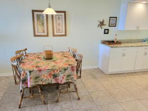 a dining room with a table and chairs and a kitchen at 408 - Very nice 2 bedroom ocean view in New Smyrna Beach +39 photos