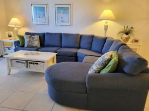 a living room with a blue couch and a table at 409 - 2/2 Stunning Condo Ocean View in New Smyrna Beach