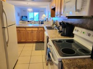 a kitchen with a stove and a white refrigerator at 409 - 2/2 Stunning Condo Ocean View in New Smyrna Beach
