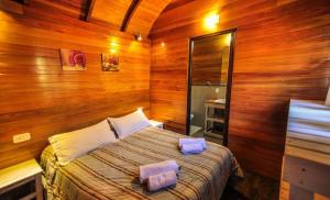 una camera da letto con un letto in una stanza con pareti in legno di Cabañas Gusfraba a Villa Gesell Altre 9 foto