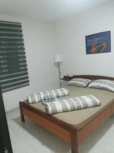 a bed with pillows on it in a room at Guesthouse NADIA in Senj