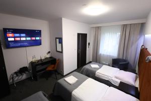 pokój hotelowy z dwoma łóżkami i telewizorem w obiekcie Hotel Junior w Krakowie