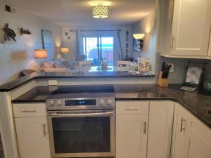 a kitchen with a stove and a living room at 202 - Adorable 1 bedroom unit - sleeps 6 in Edgewater