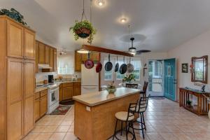 a kitchen with wooden cabinets and a island with bar stools at Hale O Makani in Keaau