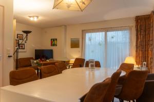 una sala de estar con una mesa y sillas en Een Ruime Vakantiehuis aan de kust in het prachtige Sint Maartenszee, en Sint Maartenszee