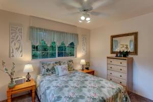 a bedroom with a bed and a dresser and a window at Hale O Makani in Keaau