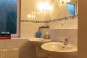 Un baño con dos lavabos y un espejo. en Een Ruime Vakantiehuis aan de kust in het prachtige Sint Maartenszee, en Sint Maartenszee 13 fotos más