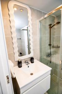 een badkamer met een witte wastafel en een douche bij Lazuli Sea View Beachfront Ap 21 in Larnaka