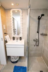 een badkamer met een wastafel en een douche bij Lazuli Sea View Beachfront Ap 21 in Larnaka +37 foto's