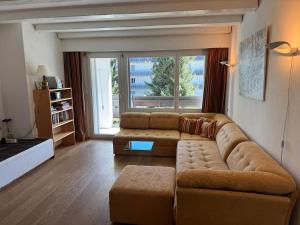 a living room with a couch and a large window at Slope-Side Mountain Apt Sleeps 4 in Laax
