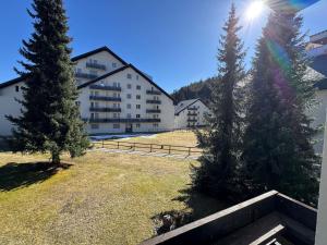 a view of a building with two trees in a yard at Slope-Side Mountain Apt Sleeps 4 in Laax