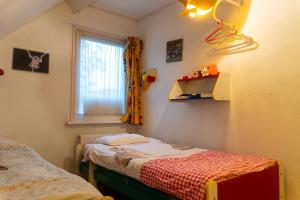 Un dormitorio pequeño con una cama y una ventana. en Een Ruime Vakantiehuis aan de kust in het prachtige Sint Maartenszee, en Sint Maartenszee