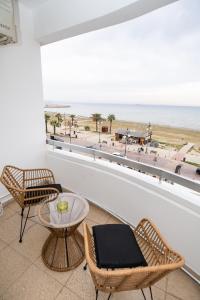 een balkon met 2 stoelen en een tafel en een strand bij Lazuli Sea View Beachfront Ap 21 in Larnaka