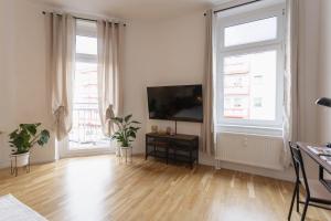 a living room with a flat screen tv and two windows at Ferienwohnung Agnes in Dessau