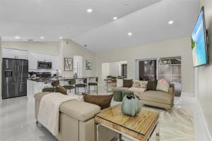 een woonkamer met banken en een tafel en een keuken bij Lux 5BDR HUGE HTD Pool NR BEACH in Naples