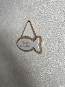 a wooden fish shaped sign hanging on a wall at Les Dunes in Saint-Hilaire-de-Riez