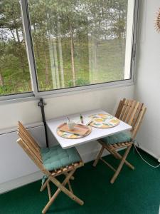 a table and two chairs in a room with a window at Les Dunes in Saint-Hilaire-de-Riez