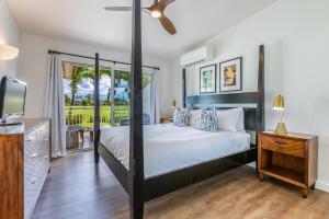 a bedroom with a large bed and a window at Emmalani Court 322 in Princeville +10 photos