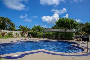 a large swimming pool in a yard with a person in it at Emmalani Court 322 in Princeville
