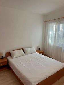 a bedroom with a bed with two pillows and a window at Bronislovas holiday home 1 in Rogoznica