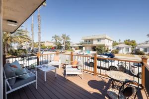 a deck with furniture and tables and a parking lot at 2BD Sashas Bungalow Beach Vibes 1 Block Away in San Diego +46 photos