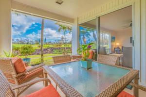 a dining room with a glass table and chairs at Hale Emmalani #311 in Princeville