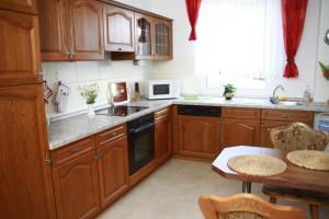 a kitchen with wooden cabinets and a table in it at Jürgen Ferienwohnung in Wernigerode